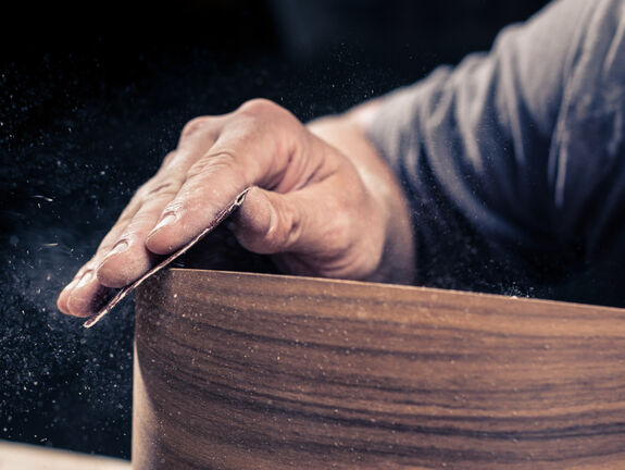 Close up of craftsman sanding a loudspeaker in the Aequo workshop